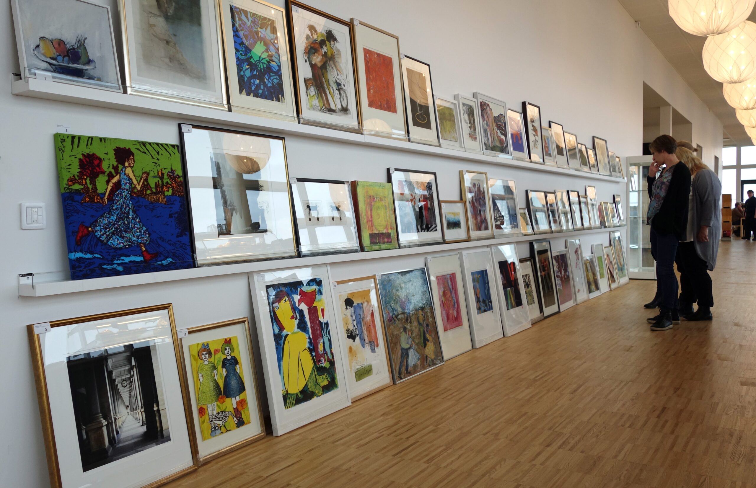 Två kvinnor som tittar på konst.